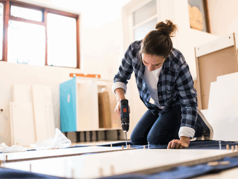Woman using a power drill to build furniture